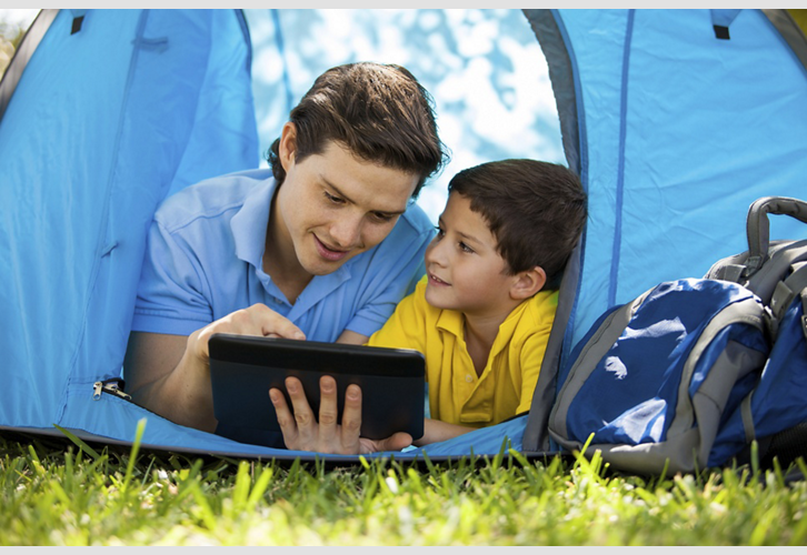 Two people in tent using a tablet
