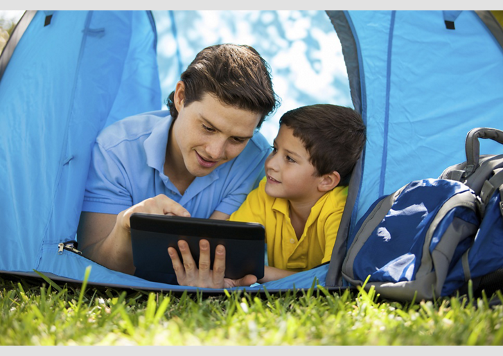 Two people in tent using a tablet