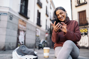 A picture of a woman smiling and looking at her phone