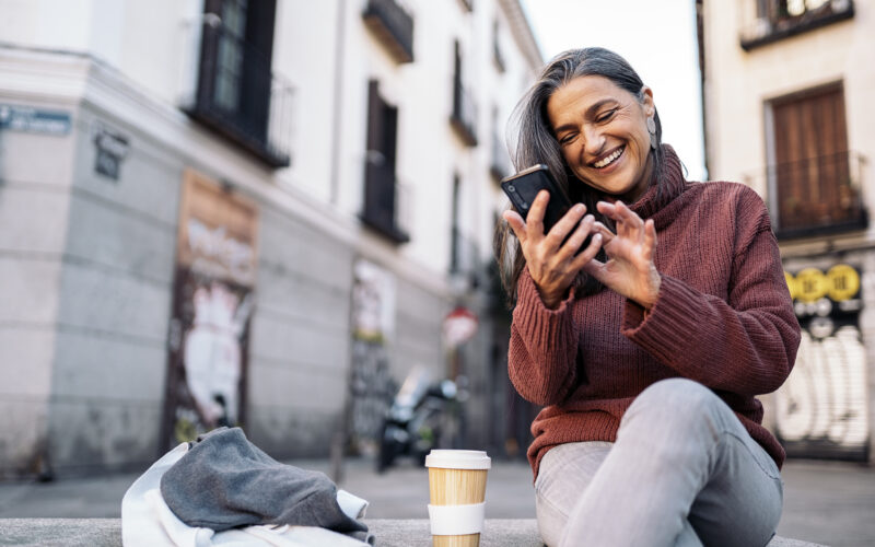 A picture of a woman smiling and looking at her phone