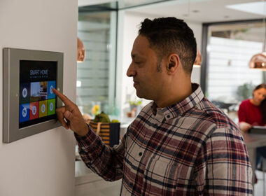 Man setting touch screen smart home alarm