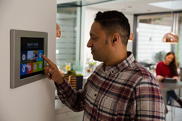Man setting touch screen smart home alarm