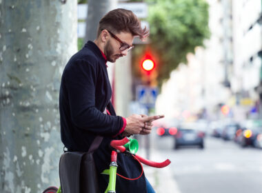 A man standing outside looking at his phone