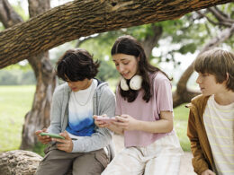 Teenagers on phones in park