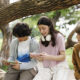 Teenagers on phones in park