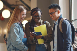 College students smiling at something on a smartphone