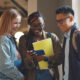 College students smiling at something on a smartphone