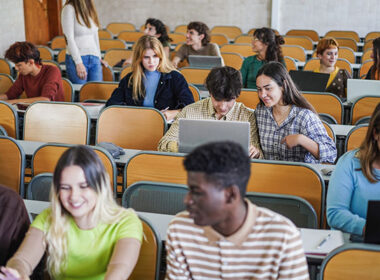 College students in a classroom looking at laptops.