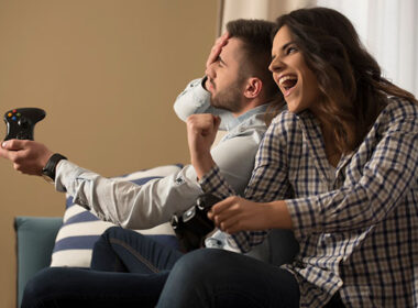happy smiling couple playing video games at home.