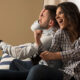 happy smiling couple playing video games at home.