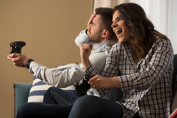 happy smiling couple playing video games at home.
