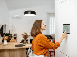 Woman at home adjusting her smart thermostat