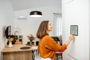 Woman at home adjusting her smart thermostat