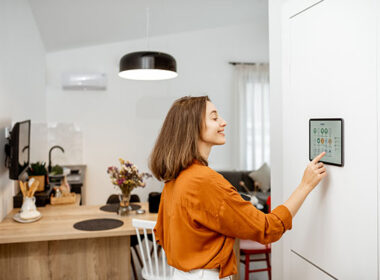 Woman at home adjusting her smart thermostat