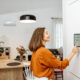 Woman at home adjusting her smart thermostat