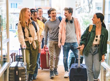 Group of university college tourist walking inside the hotel with luggage