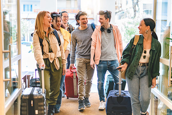 Group of university college tourist walking inside the hotel with luggage