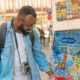 Young african american traveller man with camera choosing the souvenirs at a souvenir shop in Portugal.