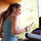 Woman Exercising On Treadmill Wearing Wireless Earphones And Smart Watch Checking Mobile Phone