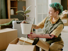 Young adult Caucasian woman with prosthetic arm unpacking cardboard box
