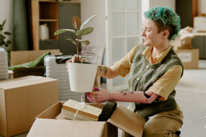 Young adult Caucasian woman with prosthetic arm unpacking cardboard box