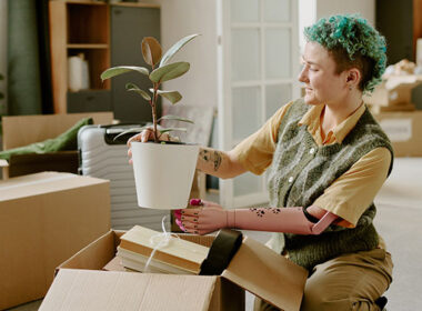 Young adult Caucasian woman with prosthetic arm unpacking cardboard box
