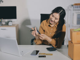 Woman holding a credit card and using smart phone for online shopping