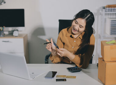Woman holding a credit card and using smart phone for online shopping