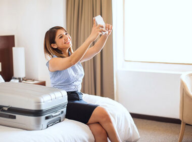 Pretty young businesswoman taking a selfie after arriving at a hotel to remember her first business trip